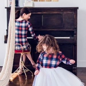 mother and daughter playing on piano