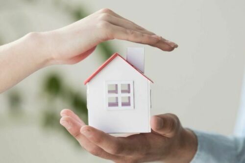 Small house model in human hands